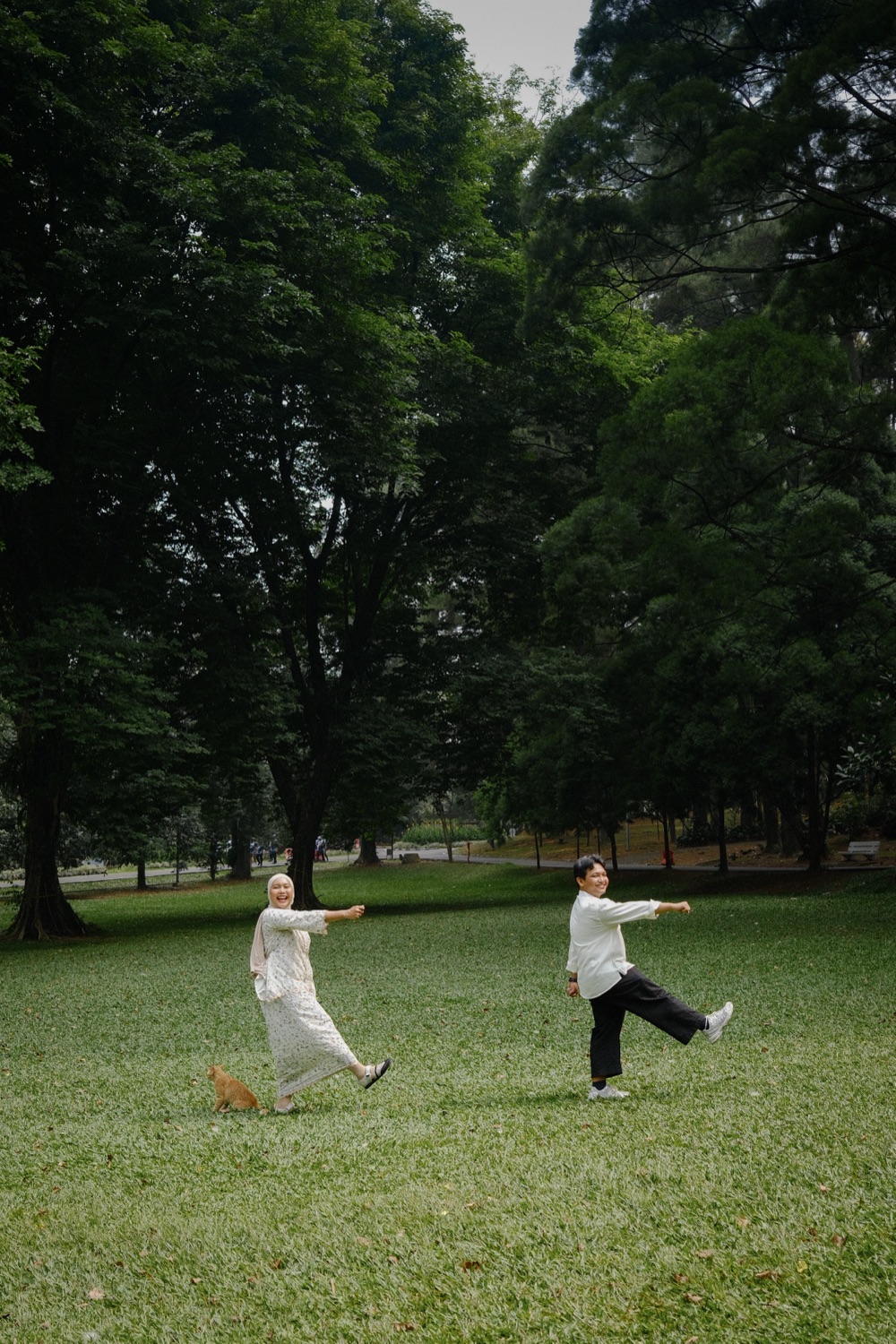 Iqbal and Deffy sharing a playful moment together in a green park.