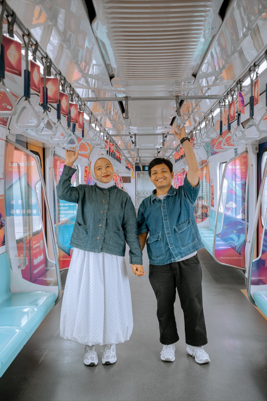 Iqbal and Deffy standing together and holding hands on a train.